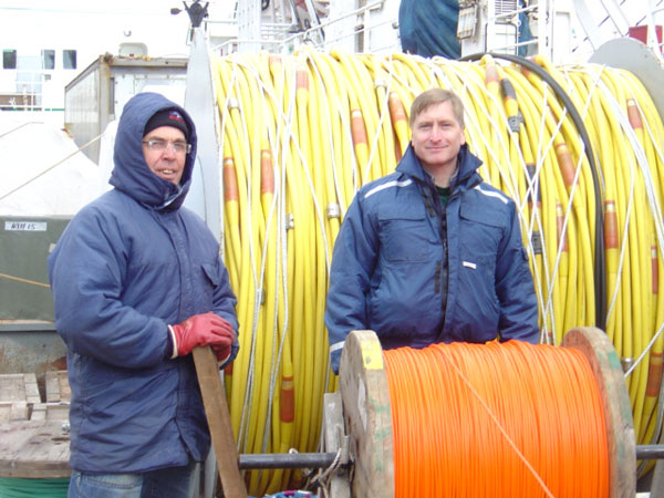 Dr. Dziak and Russian crewmember standing behind spool of nylon rope