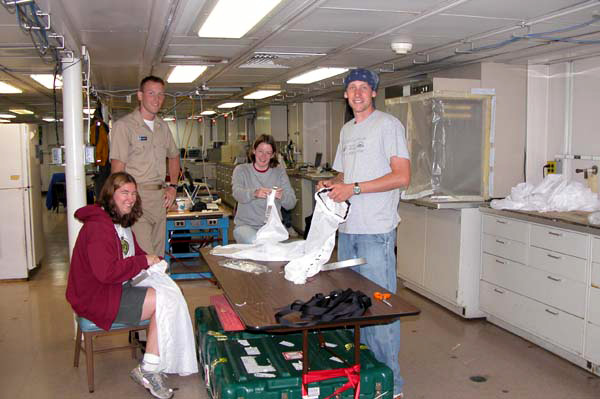 Kate Buckman of the Woods Hole Oceanographic Institution, Sarah L’Heureux of the University of Delaware, and Alex Gagnon of the California Institute of Technology craft nets to be used in collecting specimens of coral fossils, while Junior Officer, Ensign James Brinkley looks on. 
