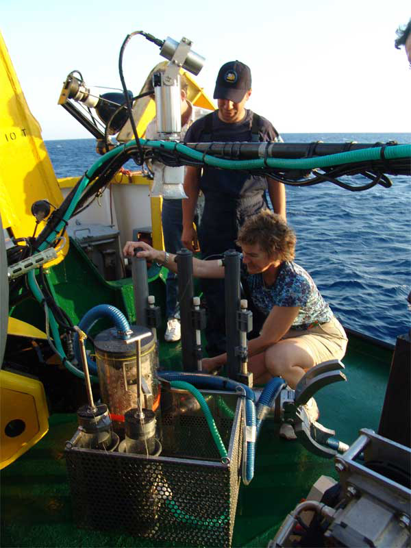WHOI senior research assistant Joanne Goudreau collects water samples from Niskin bottles attached to Thetis.
