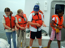 Emily, Tracey, Cameron and Brooks prepare to help lift the multi-beam sonar