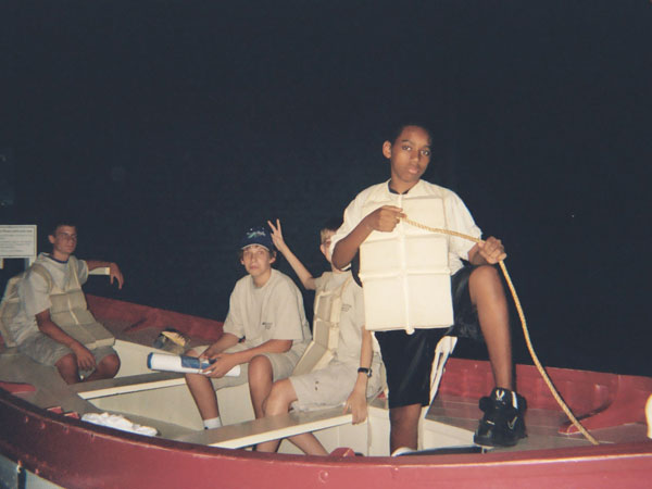 Brandon, David, Cameron and Joseph pose inside of a reproduction Titanic life boat