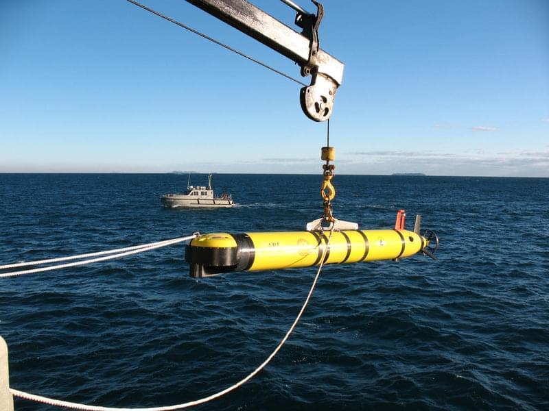 A view of the ATLAS autonomous underwater vehicle (AUV) just before being lowered into the water. Here the AUV is about 6 meters (20 feet) above the water. At this moment, the AUV is in a quiet lake and in its pre-release position, where the vehicle and software are in their final check-out. In a moment, the lines will be released and the vehicle will be sent on its way to search the lake floor.