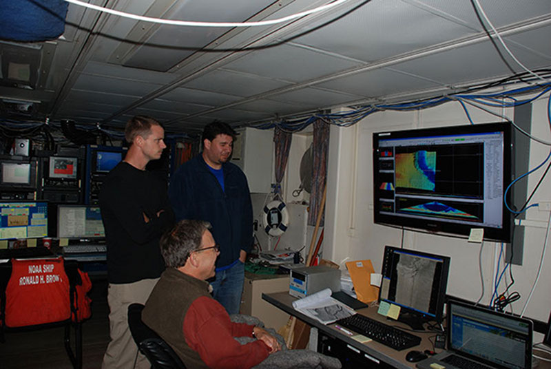 After repairing the multibeam system, Kongsberg representative Tony Dahlheim, data manager Keith Vangraafeiland, and archaeologist Frank Cantelas assess the live multibeam feed