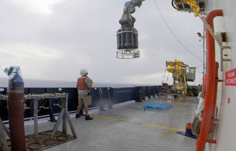 The CTD instrument package is lifted off the deck of the ship before it is lowered over the side on a cable to collect water samples and look for hydrothermal plumes.