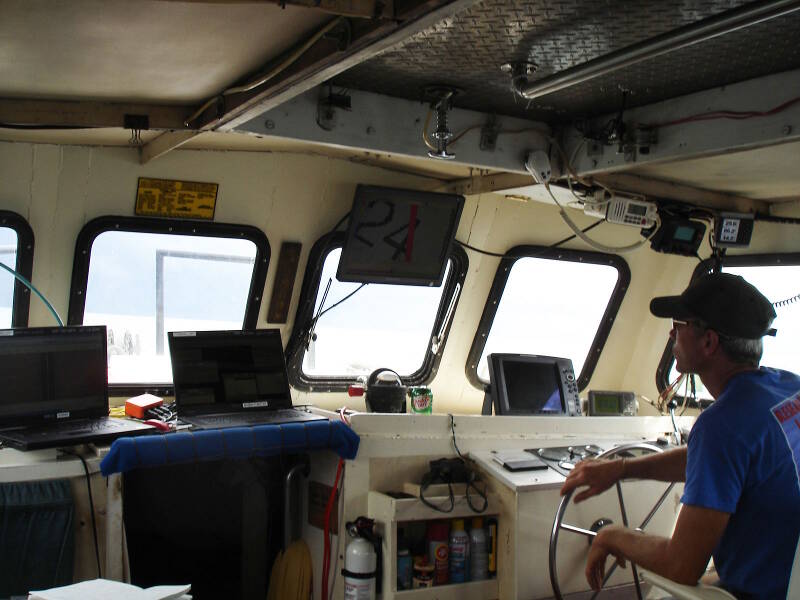Inside the cabin of the Roper, Sam Turner mans the helm surrounded by computer displays.