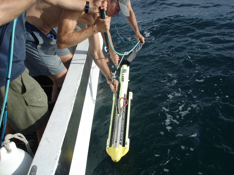 The sidescan sonar is the next device to enter the water. The magnetometer, already launched, is attached by its cable to the sidescan, so the sidescan has to be deployed immediately after the mag enters the water. 
