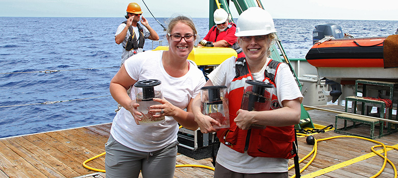 Carrying sample bins full of specimens from the remotely operated vehicle.