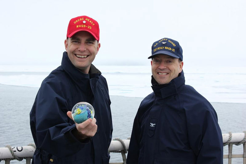 CDR William Woityra and CAPT Jason Hamilton proudly display the Planet from The Infinity Project, mentioned in the Unique Recognition for a Unique Expedition log.