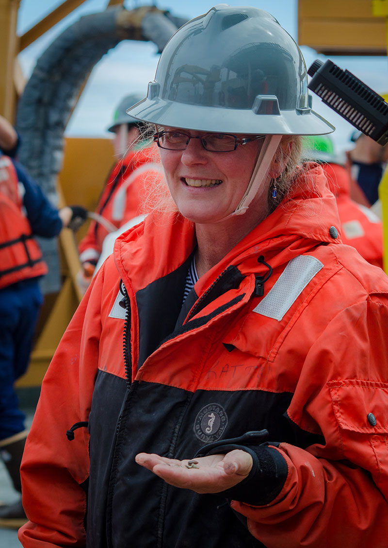 Benthos scientist Katrin Iken happily holds a couple of small bivalves collected from the box core.