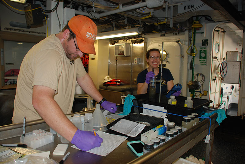 Amanda Demopoulos examines a sediment core while Jason Chaytor records her observations.