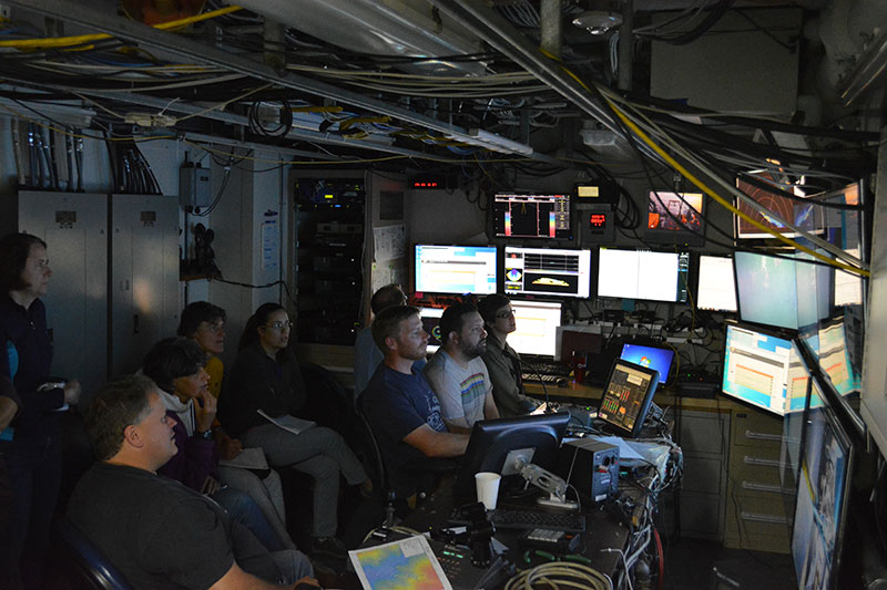 The science team gathers in the ROPOS command center aboard NOAA Ship Henry Bigelow to view images from the seafloor in the northern Gulf of Maine.