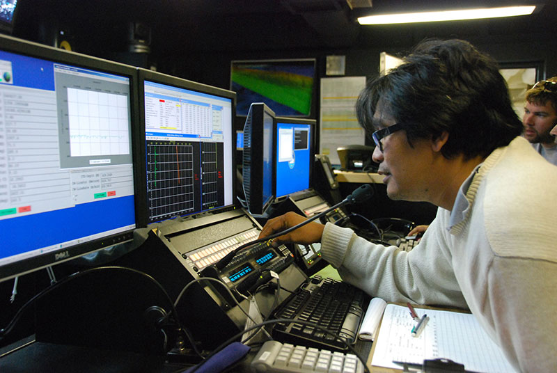 During preliminary operations near Guam, Indonesian scientist Dr. Michael Purwoadi makes the first ‘call’ using telepresence from the NOAA Ship <em>Okeanos Explorer </em>to colleagues in the newly established Jakarta Exploration Command Center.