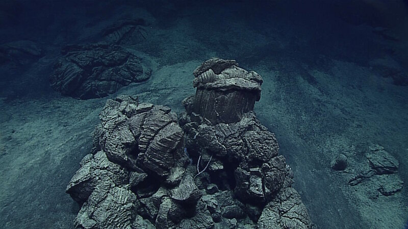 An isolated pillow outcrop surrounded by sediment.
