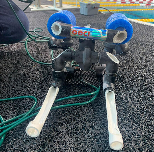 A small remotely operated vehicle (ROV) on a pool deck at a student ROV competition.