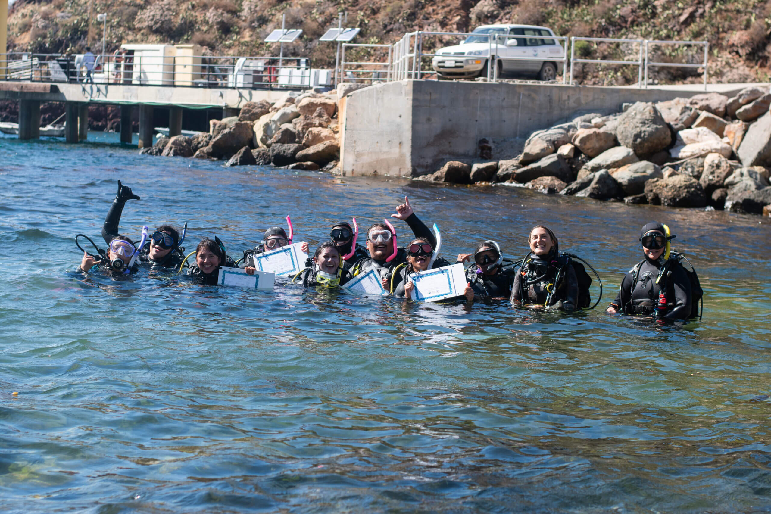 Workshop participants around a small pool containing a remotely operated vehicle.