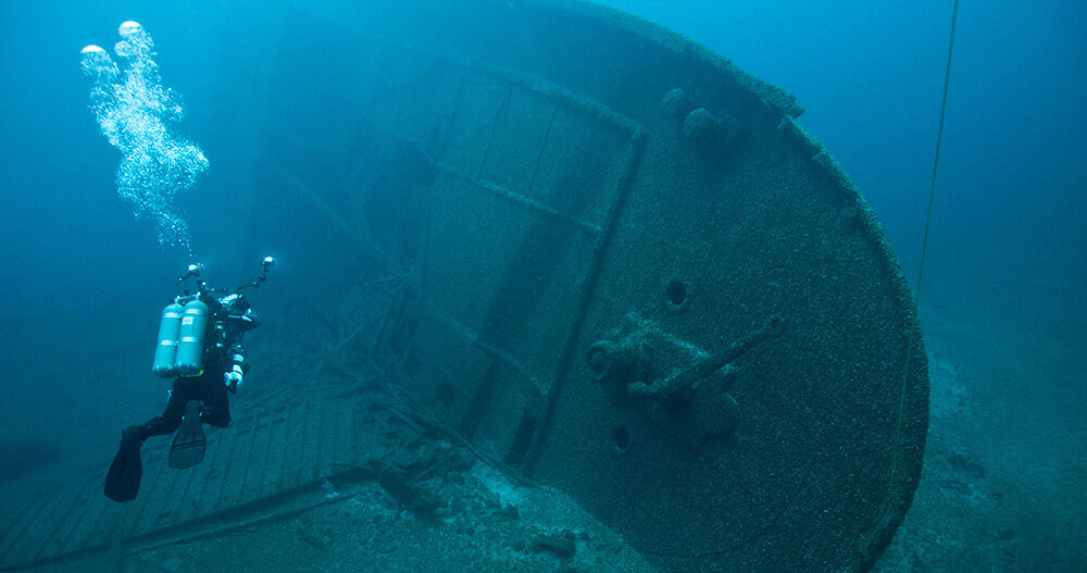 A diver explores the massive remains of the shipwreck Norman.