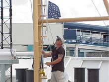 Flag from bow of ship being removed