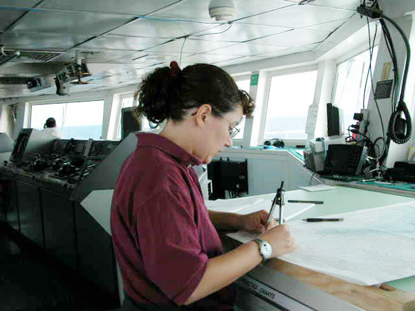 NOAA Corps Officer LTJG Jennifer Pralgo looking over a navigational chart