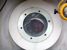 Rich Styles peers out of a porthole in the aft chamber of the JSL II submersible.