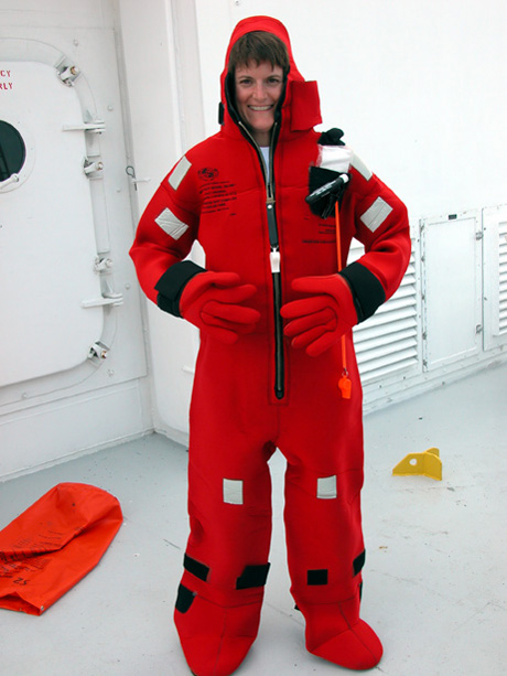 Doni Angell, an Educator-at-Sea, dons an immersion suit during a ship safety demonstration.