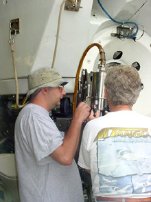 Technicians adjusting a devise on one of Alvin’s manipulator arms.
