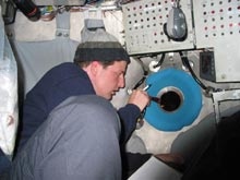 Jason Chaytor shines a flashlight out the porthole to assist Alvin pilot.