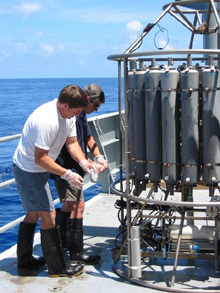 Geoff Lebon (foreground) and Ed Baker (background) are removing plume water from the CTD bottles after a tow-yo.