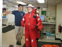 Tolland High School teacher Lance Arnold tries on a survival (Gumby) suit during ship safety drills