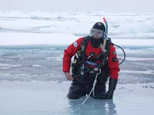 Wayne Smith, DFO Winnipeg, in his drysuit working his way back onto an ice floe after a dive in the Canada Basin.