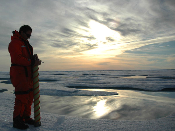 Rolf Gradinger is silhouetted by the Arctic sun while collecting one of the last ice cores of the cruise