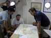 Members of the science team look at a map of Milos island to plan the next day's science operations.