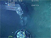 The submersible pilot grabs one of corers with the manipulator and pushes it into the sediment.