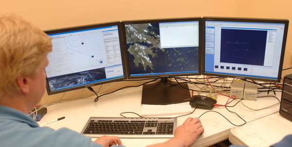 AUV technicians watch the navigational tracks of three AUVs from an office onshore