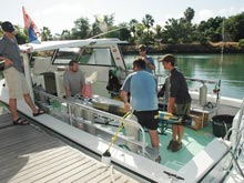 Members of the science party load the Green Flash dive boat with the two Gavia AUVs and dive tanks.