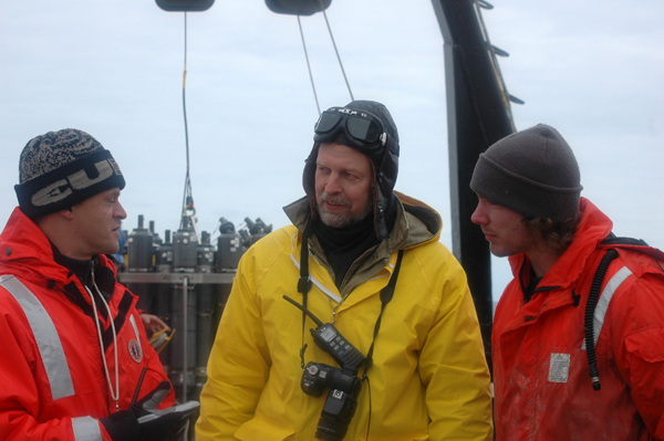 Aleksey Ostrovskiy, center, translates between Chief of Expeditions Vladimir Bakhmutov, left, and graduate student Jared Weems, right.