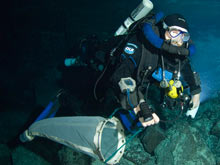 Professor Tom Iliffe, diving with a Megalodon closed circuit rebreather, tows a plankton net through an underwater cave to collect small animals. 