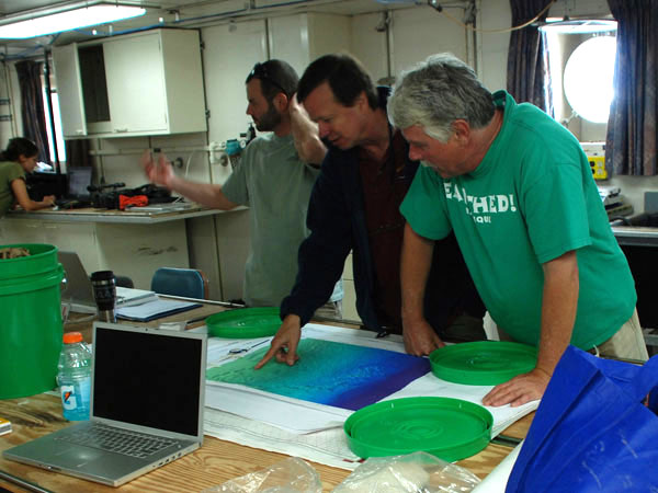 Erik Cordes, Chuck Fisher and Bill Shedd (left to right) looking at high quality multibeam bathymetry maps to locate probable sites.