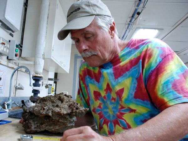 Bill Shedd examines a sample of authigenic carbonate collected at AT47. This rock is formed in the sediment through bacterial consumption of hydrocarbons. 