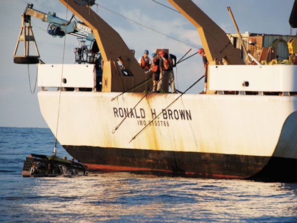 Crew members of the NOAA Ronald H. Brown work together to recover Medea.