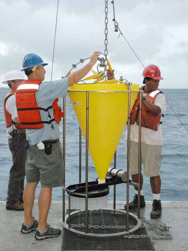 Crew of the RV Ron Brown deploying sediment trap. Mooring Specialist Steve Murphy from WHOI and Acting Chief Bosun Reggie Williams (right) oversee the operation. 