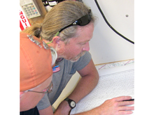 Drs. Loebel and Hemmings plan the orientation of the track lines and dimensions of the 'box' for the sidescan sonar and subbottom profiling over Ray Hole Sink.