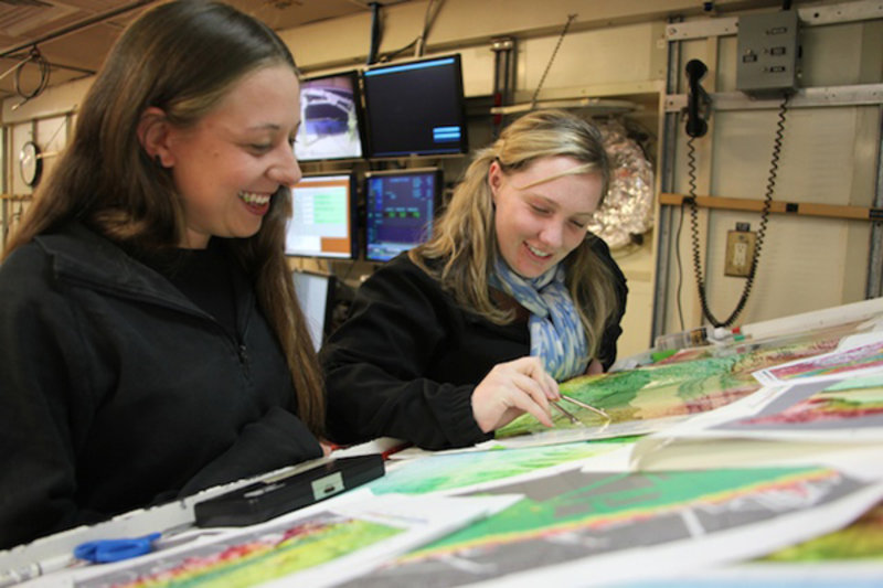 Figure 2. Ashlee Henig (right) discusses study locations at the map table with fellow graduate student Monica Heintz.