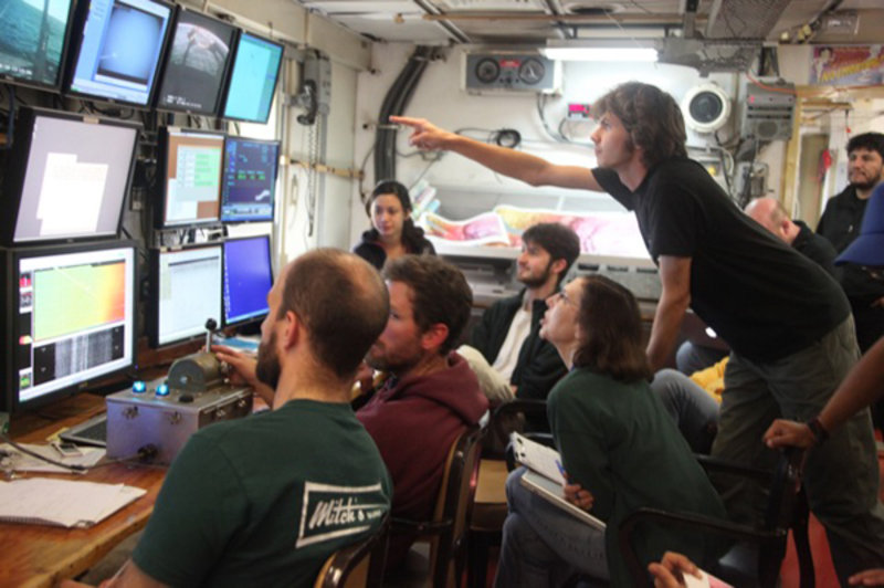 Scientists and research technicians are glued to the multicore video monitors. Ben Grupe points out a sea cucumber.