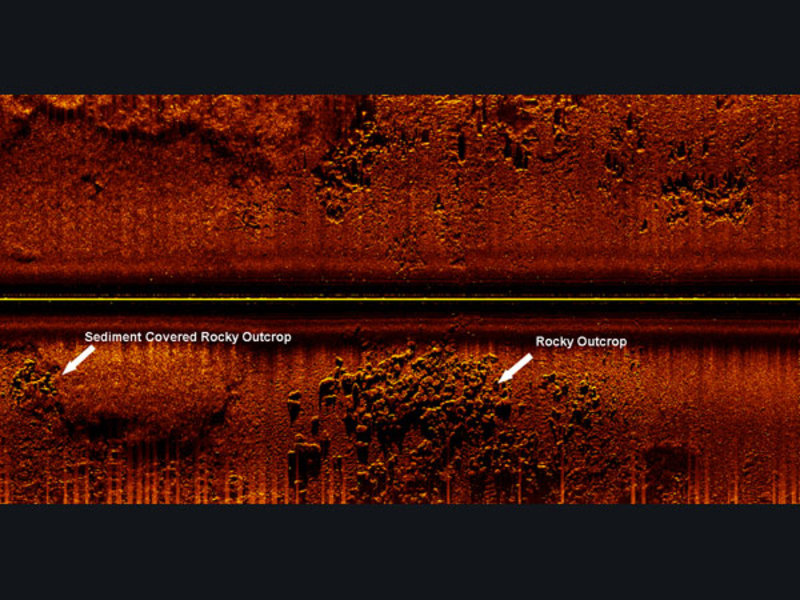 Side scan image collected from Gulf of Mexico. Rocky outcrop in bottom center of image, bottom left is rock outcrop covered in sediment. During diver investigation, these area yielded cultural material.