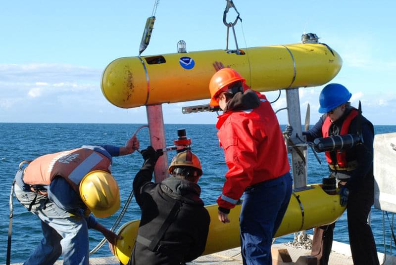 The AUV team placing the AUV on deck after a mission.
