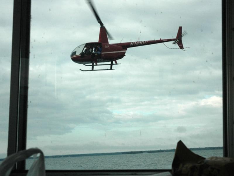 A helicopter film crew records the launch of the ATLAS, while the research team on the research vessel (R/V) Storm photographs the excitement through the windows.