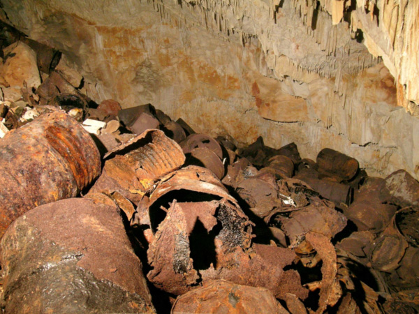 Rusting oil drum, some still with black residue inside, dumped in Bitumen Cave in Bermuda.