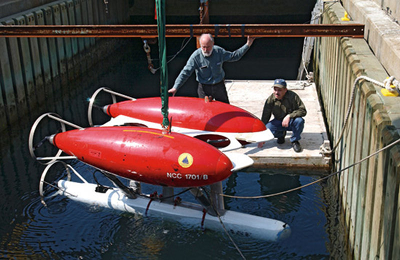 Before ABE's first deployment, ABE’s inventors, Al Bradley (left) and Dana Yoerger, tested the autonomous underwater vehicle in the test well at the WHOI dock in Woods Hole.