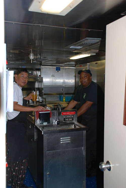 Lito Llena, Chief Steward and Greg Gordon, 2nd cook, have just finished stuffing us – again – and cleaning the galley. Now they are ready to knock off for the evening.