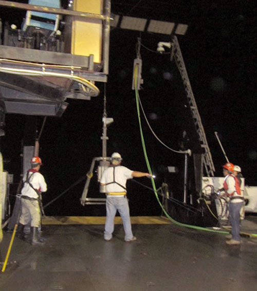 The box core is lowered off the back deck of the NOAA Ship Nancy Foster using a winch.
